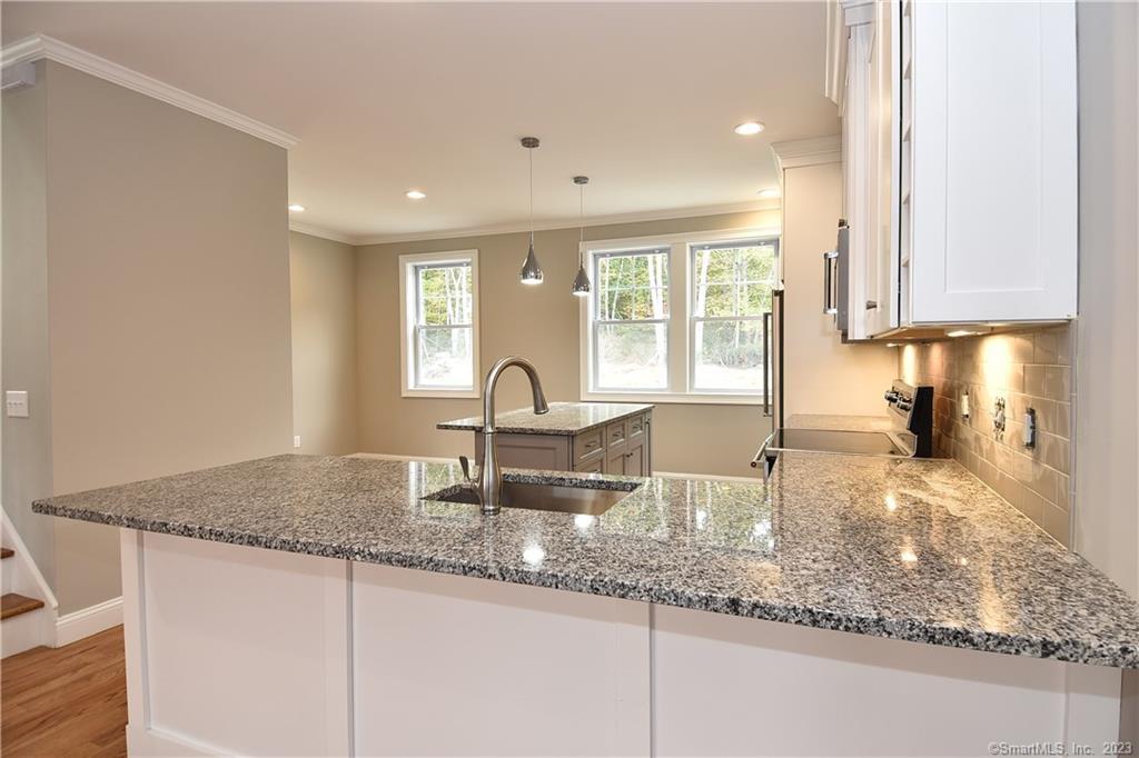 46 Village Crossing, Unit 46 Niantic, CT 06357 - Photo 6 of 24 a kitchen with granite countertop a sink and a counter top space