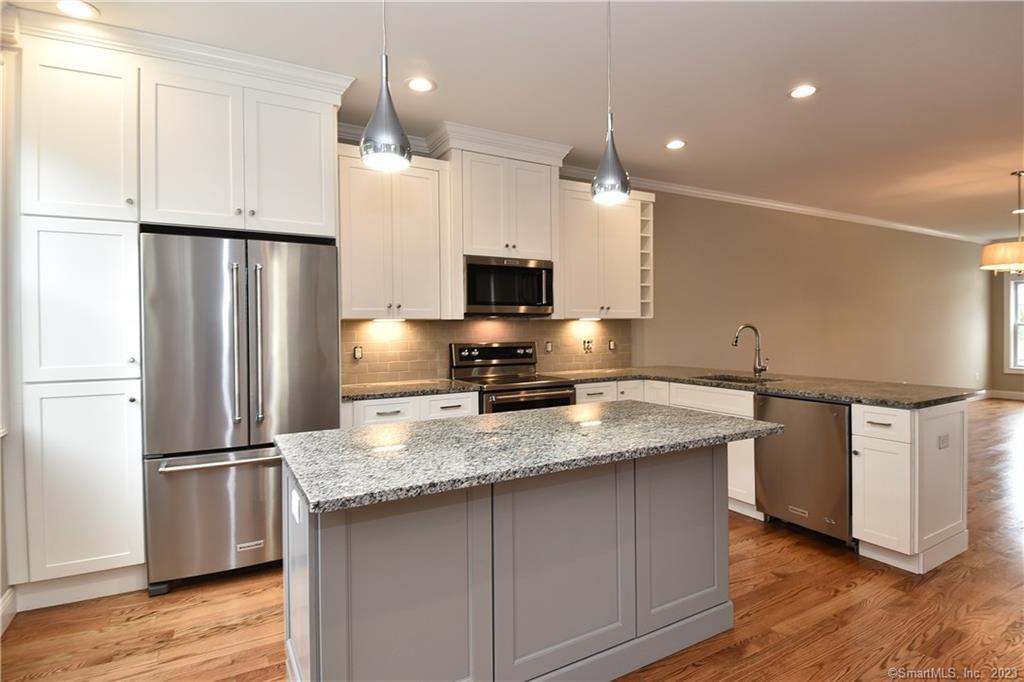 46 Village Crossing, Unit 46 Niantic, CT 06357 - Photo 7 of 24 a kitchen with stainless steel appliances granite countertop a refrigerator a sink and a stove