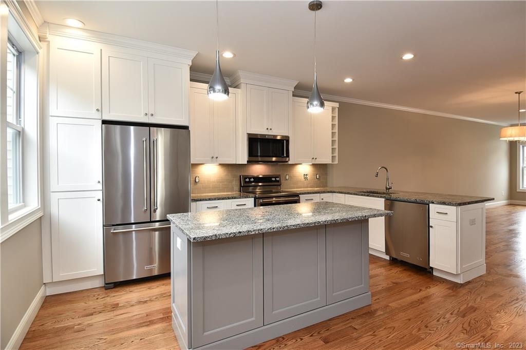 46 Village Crossing, Unit 46 Niantic, CT 06357 - Photo 8 of 24 a kitchen with stainless steel appliances granite countertop a refrigerator a sink and a stove