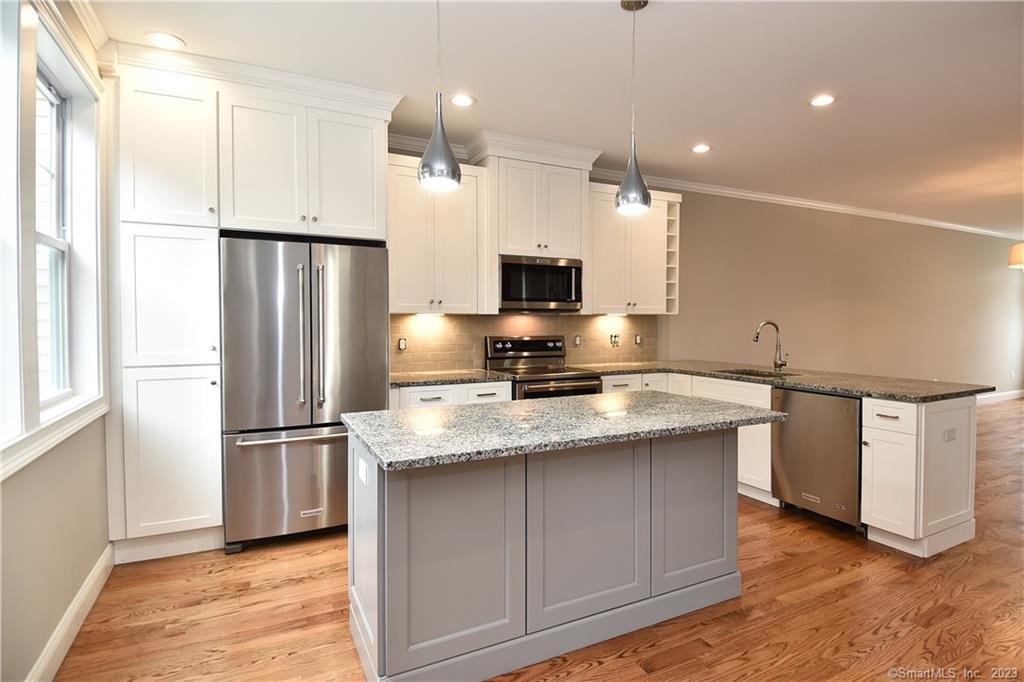 46 Village Crossing, Unit 46 Niantic, CT 06357 - Photo 9 of 24 a kitchen with stainless steel appliances granite countertop a refrigerator a stove a sink and a microwave