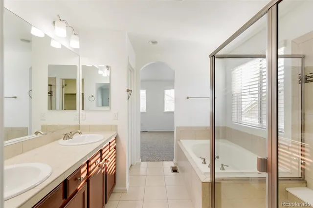 a spacious bathroom with a double vanity sink and a mirror