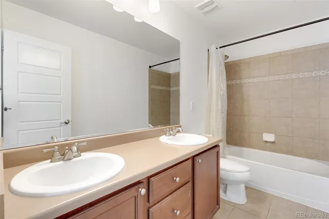 a bathroom with a double vanity sink toilet mirror and shower
