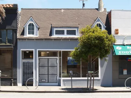 a view of a brick house with large windows and a potted plant