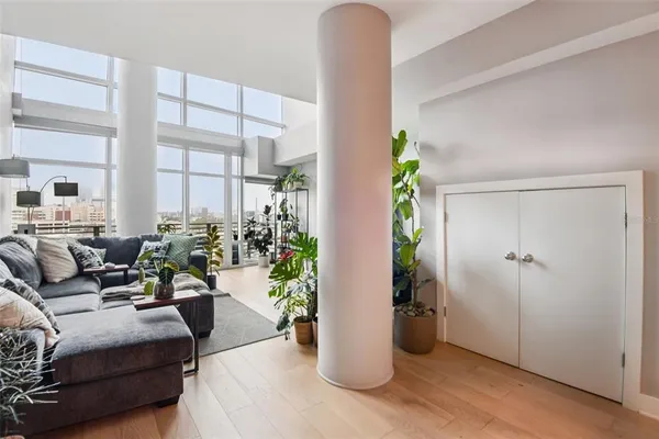 a living room with furniture flowers and a potted plant