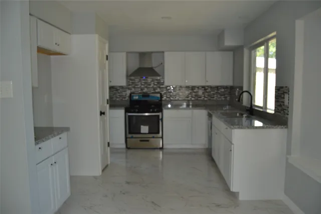 a kitchen with stainless steel appliances granite countertop a stove and a refrigerator