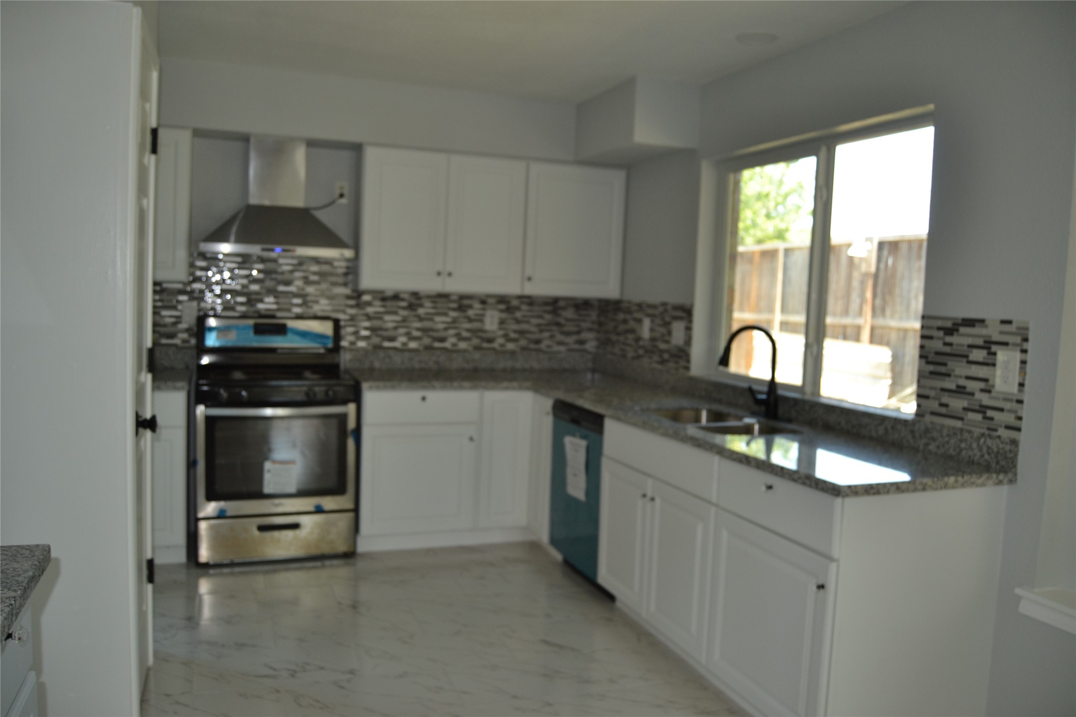 2242 Gray Hawk Lane Katy, TX 77449 - Photo 12 of 32 a kitchen with granite countertop a stove a sink and a granite counter tops