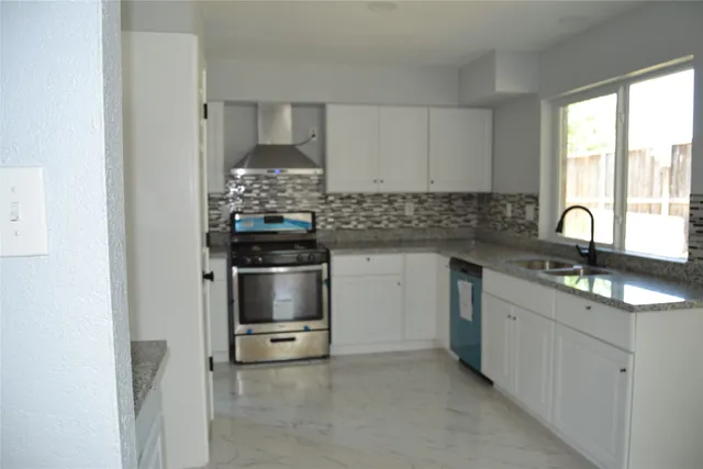 a kitchen with stainless steel appliances a stove sink and cabinets