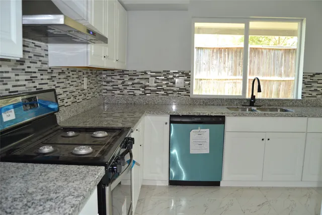 a kitchen with a sink stove and cabinets