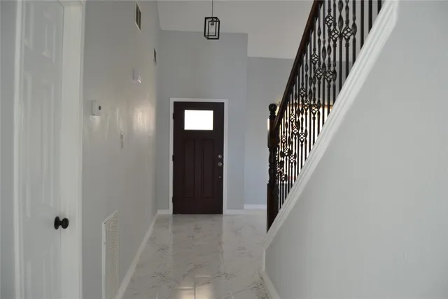 a view of a hallway with wooden floor and entryway