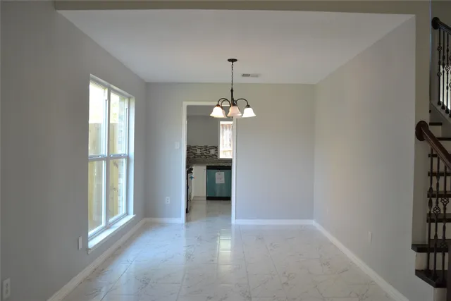a view of a livingroom with a chandelier fan and windows