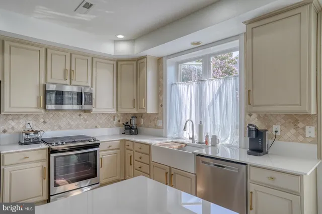 a kitchen with appliances a sink and cabinets