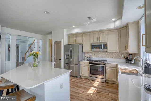 a kitchen with stainless steel appliances granite countertop a sink a stove and a refrigerator