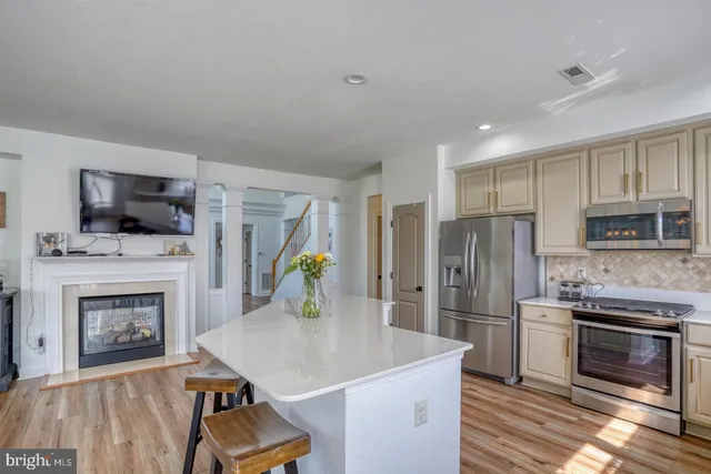 a kitchen with stainless steel appliances a stove refrigerator and a fireplace