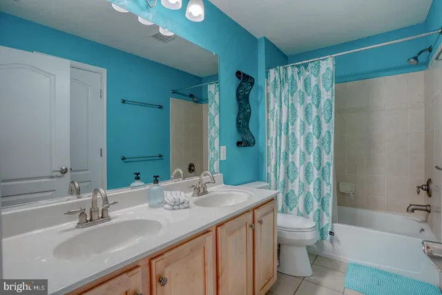 a bathroom with a double vanity sink toilet and shower