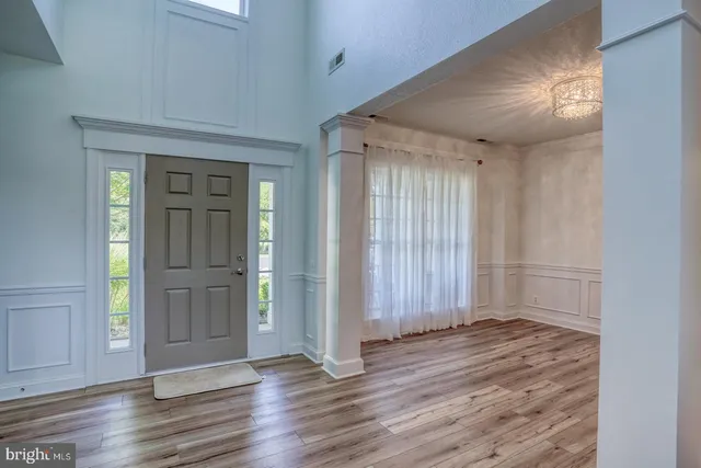 an empty room with wooden floor & windows
