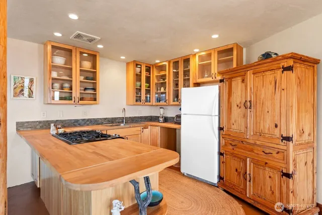 a kitchen with stainless steel appliances granite countertop a refrigerator and a stove top oven
