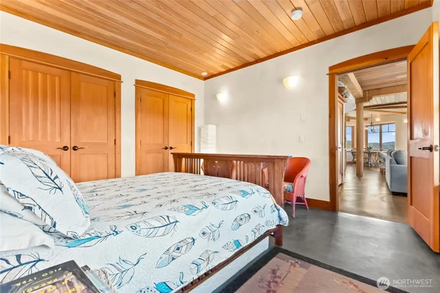 a bedroom with a large bed and wooden floor
