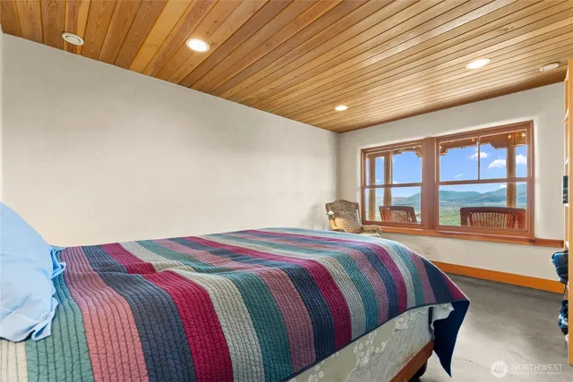 a bed sitting in a bedroom next to a large window