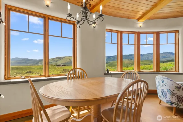a dining room with furniture a chandelier and wooden floor