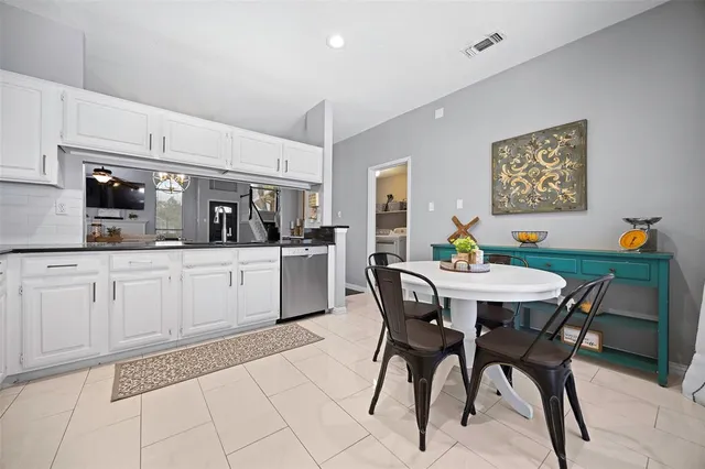 a view of a livingroom and dining room with furniture wooden floor a rug and a chandelier