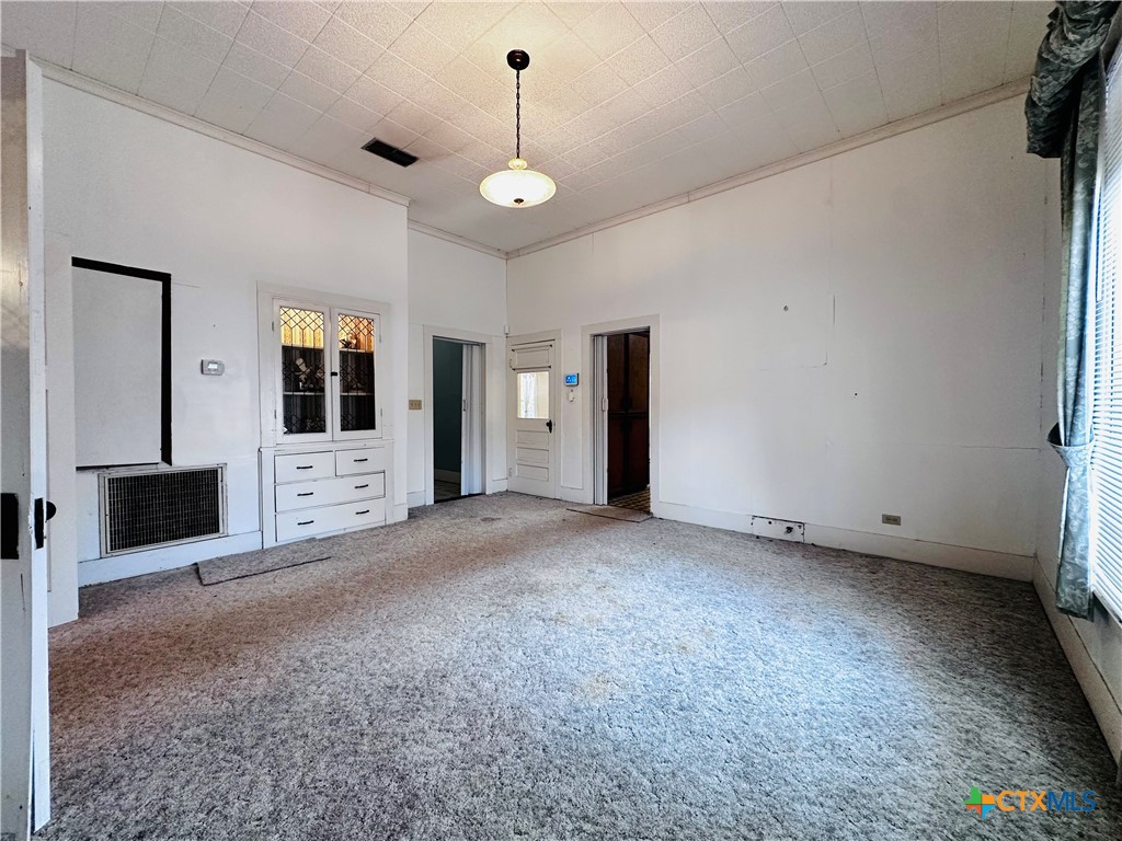 608 Coke Street Yoakum, TX 77995 - Photo 9 of 22 a view of an empty room with a fireplace and a window