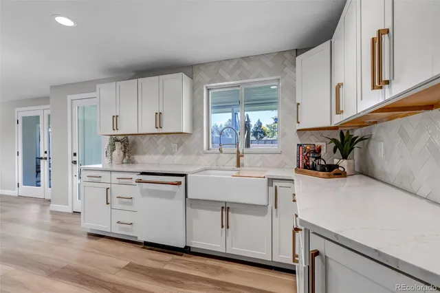 a kitchen with white cabinets and sink