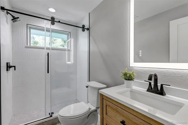 a bathroom with a sink toilet vanity and shower
