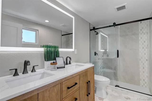 a bathroom with a sink a toilet and shower