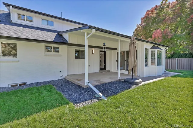 a view of a house with a yard and wooden fence