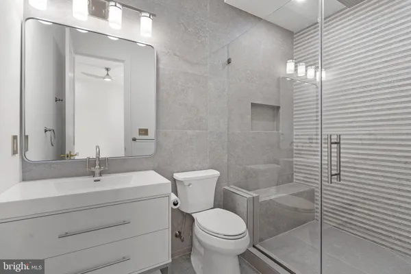 a bathroom with a sink a toilet and shower