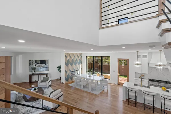 a kitchen with stainless steel appliances granite countertop a dining table chairs and white cabinets