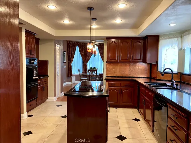 a kitchen with stainless steel appliances kitchen island granite countertop a refrigerator and a stove top oven