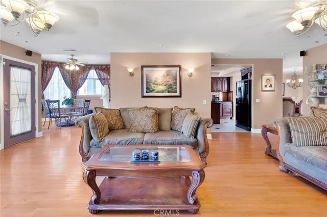a living room with furniture a chandelier and a flat screen tv