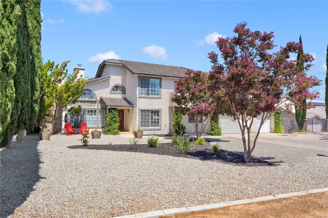 a front view of a house with a garden and plants