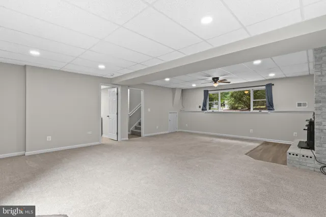 a front view of a house with a garden and trees