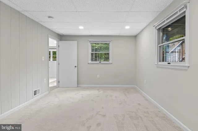 a view of a house with a yard and large tree