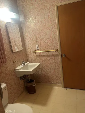 a bathroom with a sink a toilet and mirror