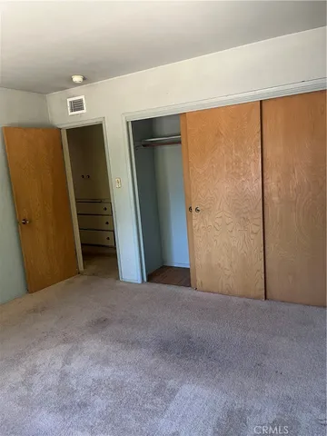 an empty room with a window and a ceiling fan