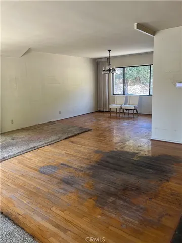 a view of empty room with wooden floor and fireplace
