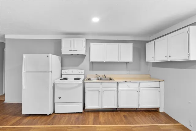 a kitchen with a white cabinets and refrigerator