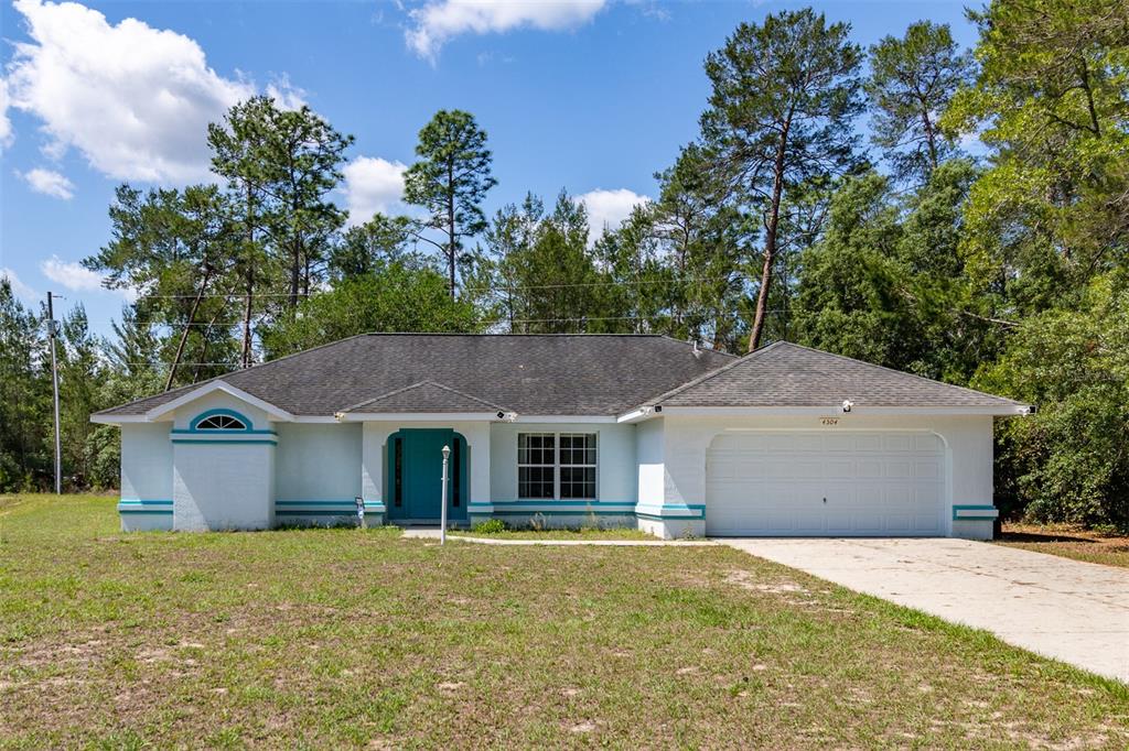 4504 Southwest 170th Street Road Ocala, FL 34473 - Photo 1 of 1 a front view of house with yard and trees in the background
