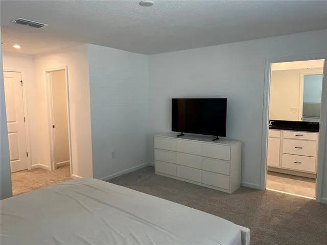 a bedroom with a bed and flat screen tv