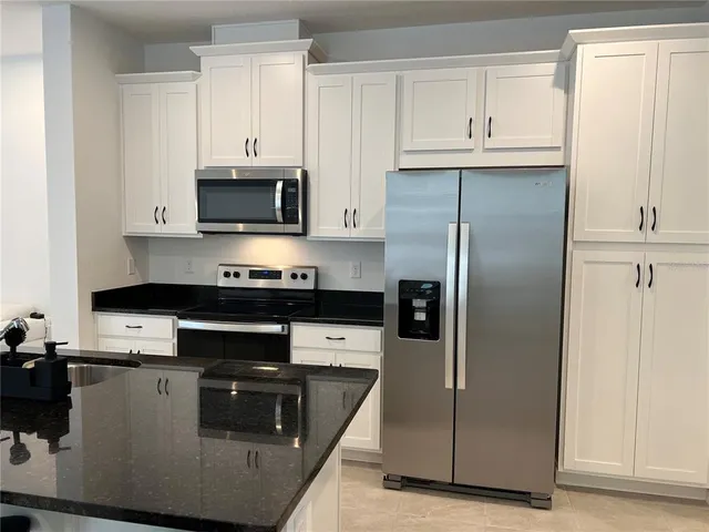 a kitchen with granite countertop a refrigerator and a stove