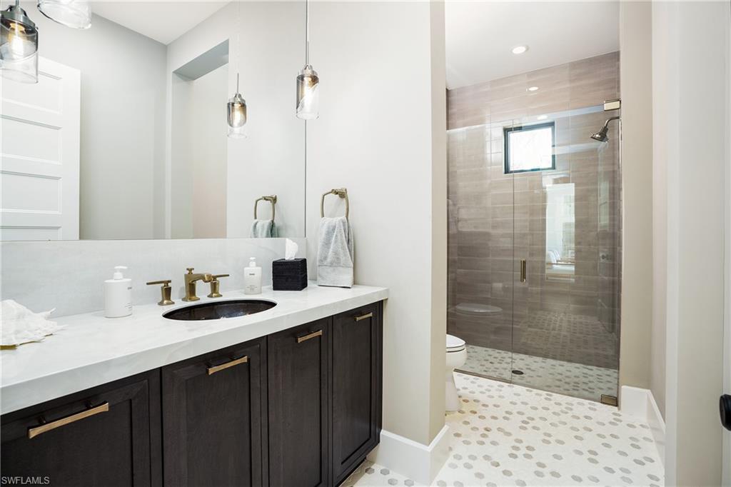 16708 Lucarno Way Naples, FL 34110 - Photo 31 of 46 a bathroom with a sink a shower and a mirror