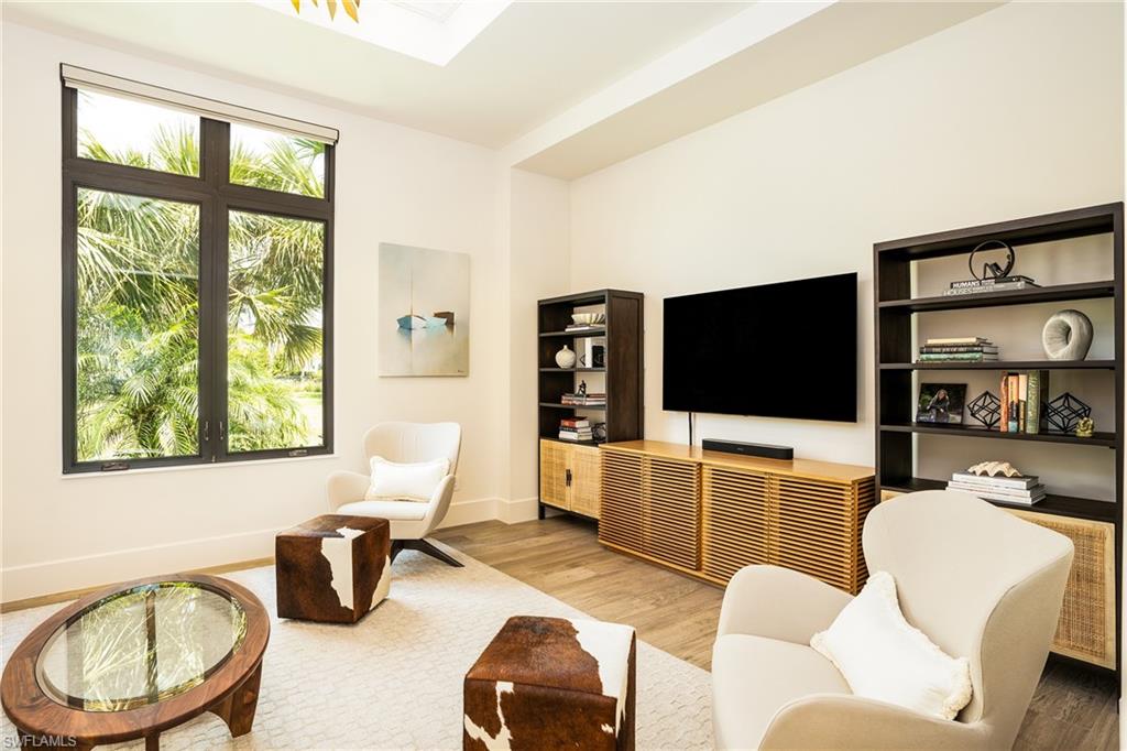 16708 Lucarno Way Naples, FL 34110 - Photo 32 of 46 a living room with furniture a flat screen tv and a large window