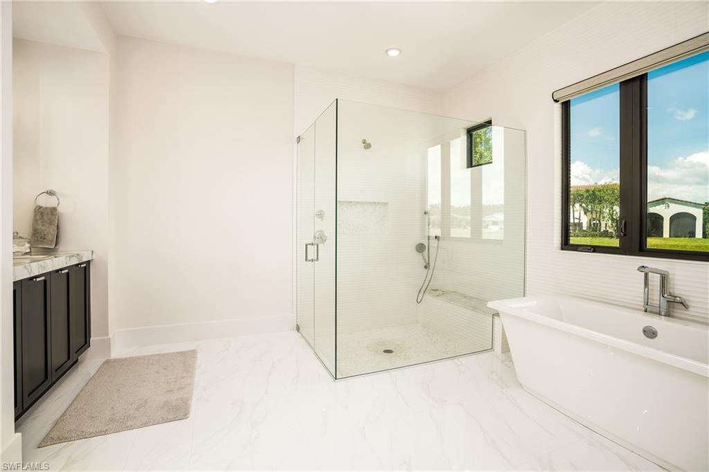 16708 Lucarno Way Naples, FL 34110 - Photo 36 of 46 a spacious bathroom with a tub shower and windows