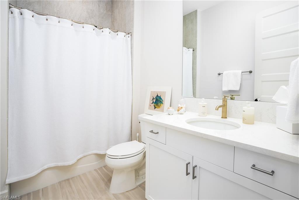 16708 Lucarno Way Naples, FL 34110 - Photo 41 of 46 a bathroom with a sink a toilet and vanity
