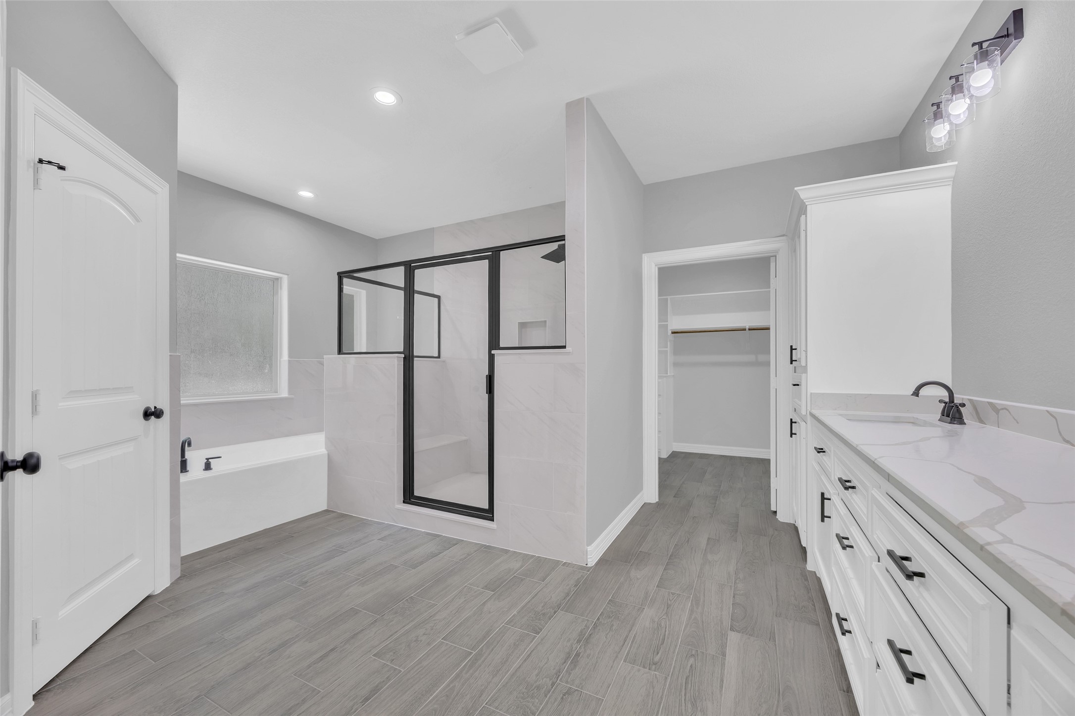 162 Bighorn Road Huntsville, TX 77340 - Photo 23 of 48 This bathroom features a modern design with a glass-enclosed shower, freestanding bathtub, and dual sinks with ample counter space. The room includes a spacious walk-in closet, sleek fixtures, and a neutral color palette for a clean, contemporary look.