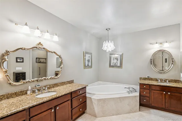 a bathroom with a granite countertop double vanity sink and a mirror