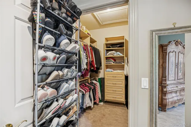 a view of walk in closet with clothes and shoes